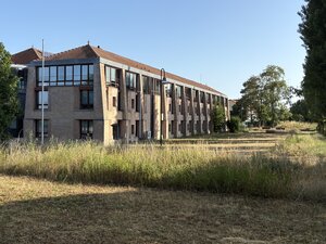 Auf dem Bild sieht man die Verbandsgemeindeverwaltung Jockgrim, davor die Wiese, die in Streifen gestutzt wurde.