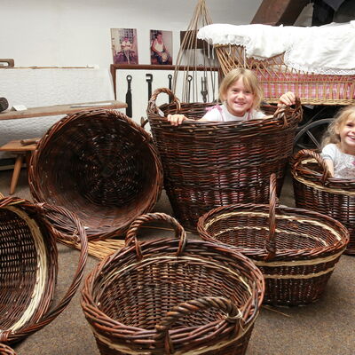 Bild vergrößern: Zwei Mädchen in Weidenkörben im Heimatmuseum Neupotz