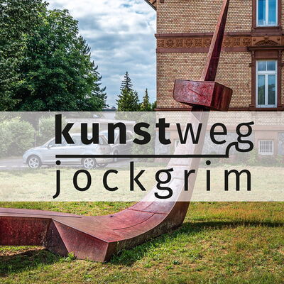 Bild vergrößern: Logo des Kunstwegs Jockgrim - im Hintergrund Rathaus der Ortsgemeinde Jockgrim
