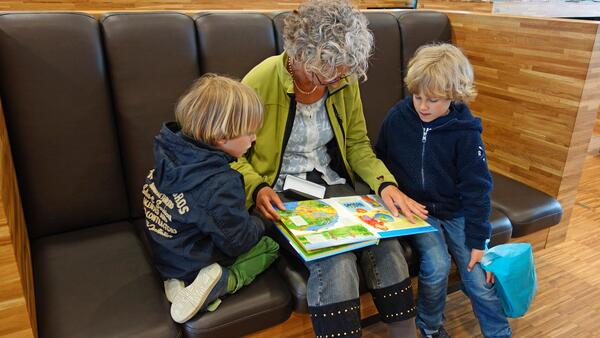 Bild vergrößern: Oma liest Enkel vor